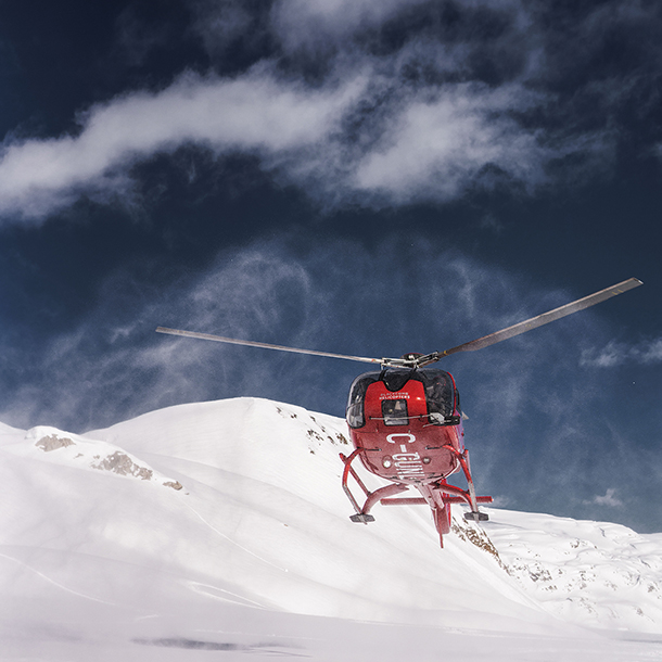 Red helicopter taking passenger to remote glacier